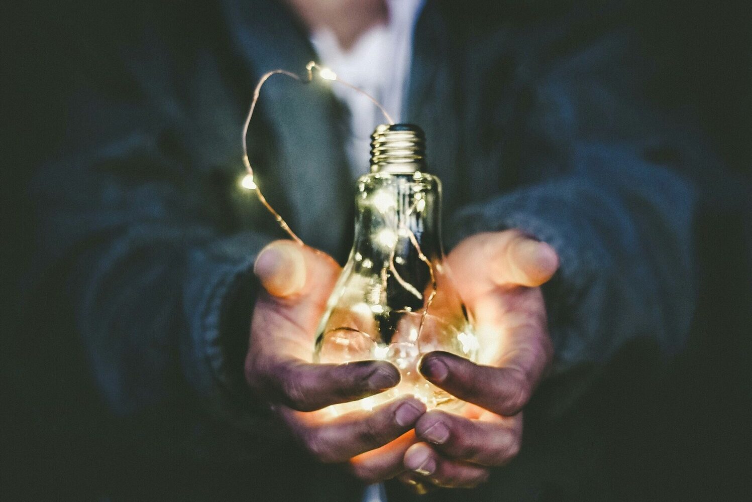 man holding incandescent bulb